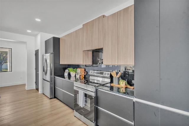 kitchen featuring stainless steel appliances, light wood-type flooring, backsplash, and light brown cabinetry