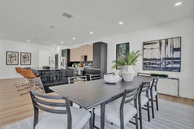 dining space featuring sink and light hardwood / wood-style flooring