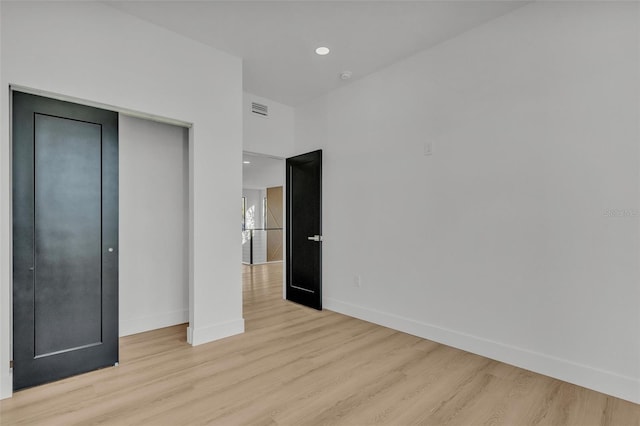 unfurnished bedroom featuring light wood-type flooring and a closet