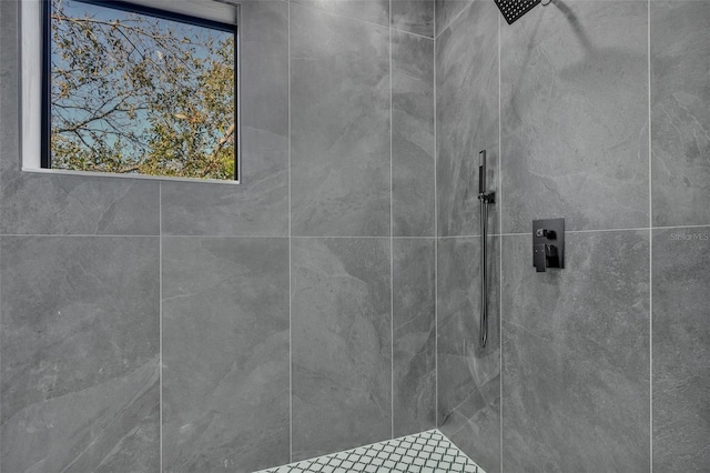 interior details featuring tiled shower