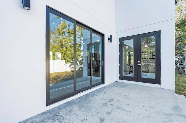 view of exterior entry with a patio area and french doors