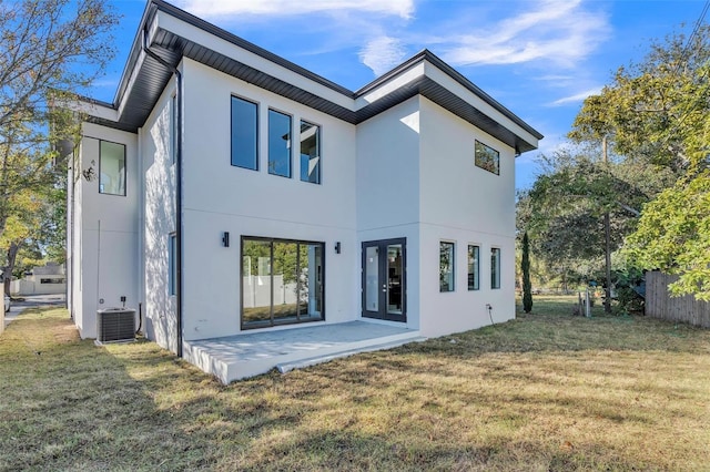 rear view of property featuring central AC unit, a yard, and a patio