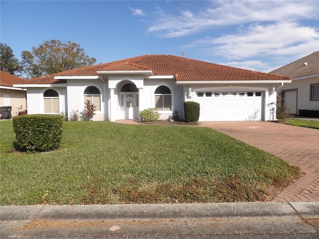 mediterranean / spanish-style house with a garage and a front lawn