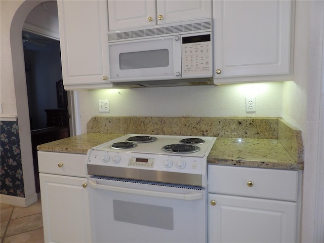 kitchen with white cabinetry, white appliances, light stone counters, and light tile patterned floors