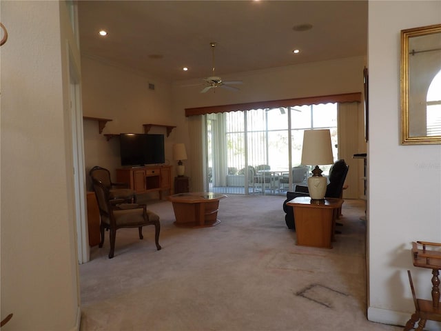 living room with light carpet, ornamental molding, and ceiling fan