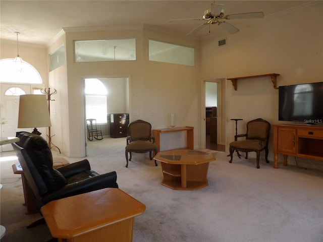 carpeted living room featuring crown molding, ceiling fan, and a towering ceiling