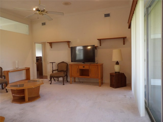 living room featuring crown molding, light colored carpet, and ceiling fan