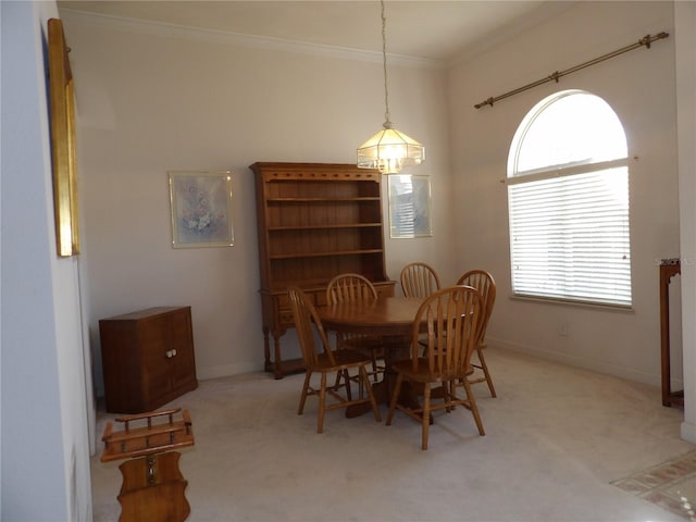 dining space featuring ornamental molding and light carpet