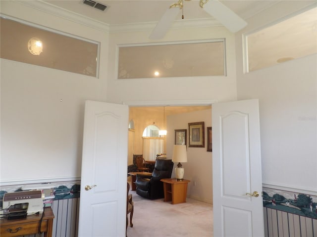 interior space featuring radiator heating unit, crown molding, and light colored carpet