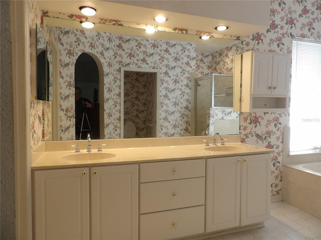 bathroom with independent shower and bath, vanity, plenty of natural light, and tile patterned floors