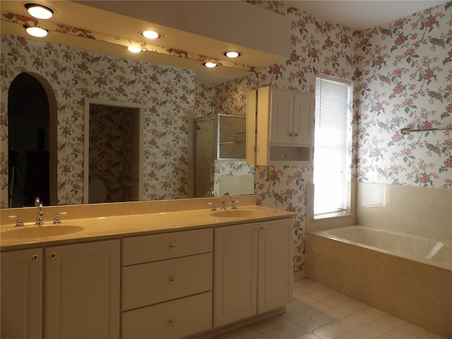 bathroom with vanity, tile patterned flooring, and plus walk in shower