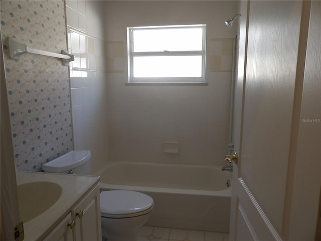 full bathroom featuring tiled shower / bath, vanity, toilet, and tile patterned flooring