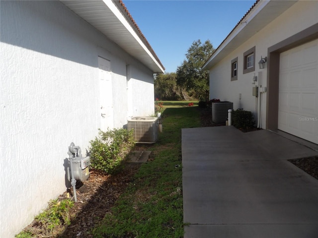 view of home's exterior featuring central AC unit and a garage