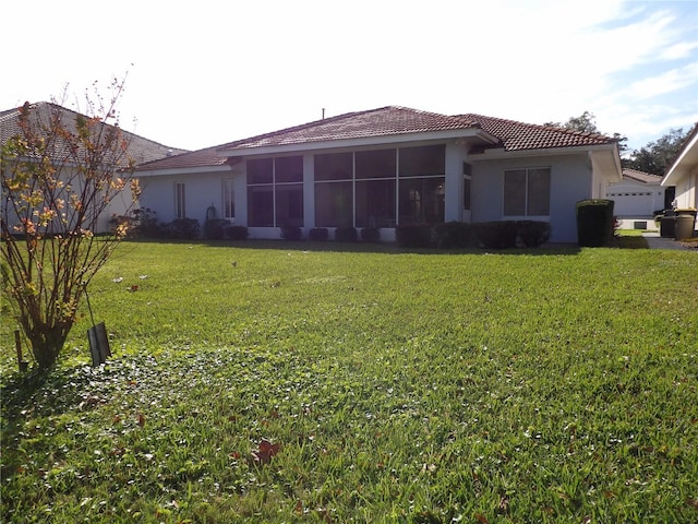 rear view of property with a sunroom and a yard