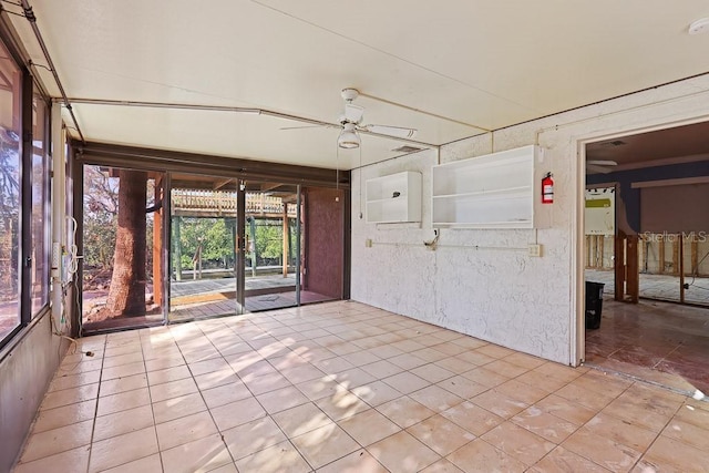 unfurnished sunroom with ceiling fan