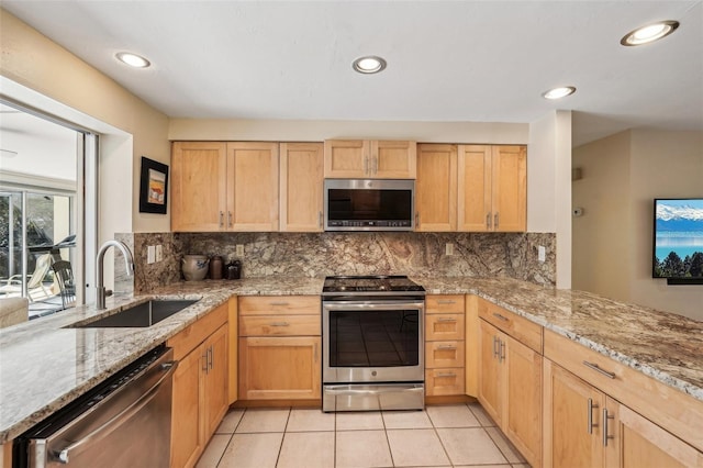 kitchen featuring light brown cabinetry, sink, backsplash, light tile patterned floors, and stainless steel appliances