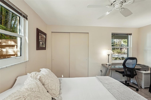 bedroom with ceiling fan, a closet, and light tile patterned floors