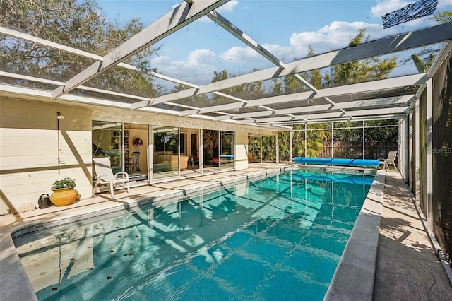 view of swimming pool featuring a patio area and glass enclosure