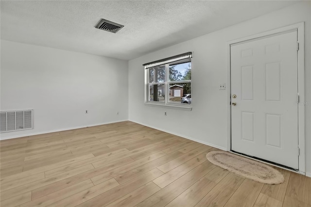 entrance foyer featuring a textured ceiling and light hardwood / wood-style floors