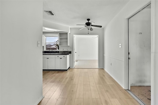 kitchen with sink, ceiling fan, and light hardwood / wood-style flooring