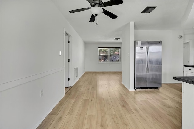 kitchen featuring ceiling fan, stainless steel fridge, and light wood-type flooring