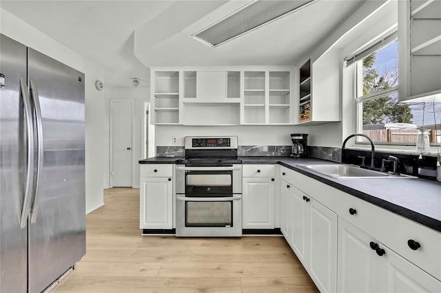 kitchen with white cabinetry, stainless steel appliances, sink, and light wood-type flooring