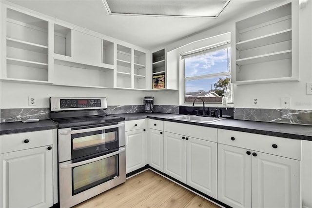 kitchen featuring double oven range, sink, white cabinets, and light wood-type flooring