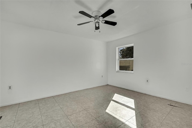 tiled spare room featuring ceiling fan