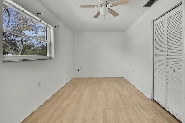 unfurnished bedroom featuring light hardwood / wood-style flooring, a closet, and ceiling fan