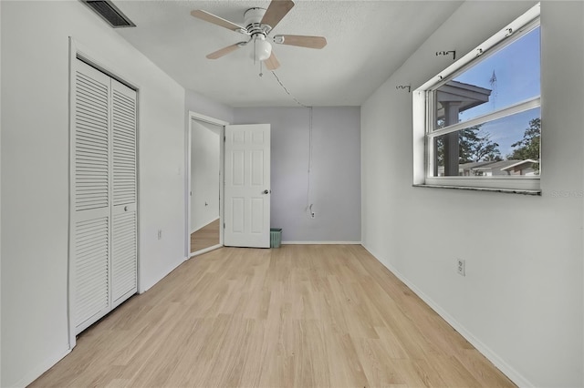 unfurnished bedroom featuring ceiling fan, light hardwood / wood-style flooring, and a textured ceiling