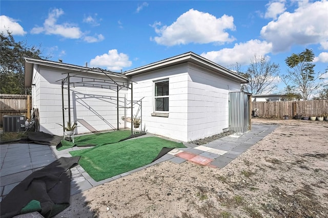 view of property exterior featuring central AC and a lawn