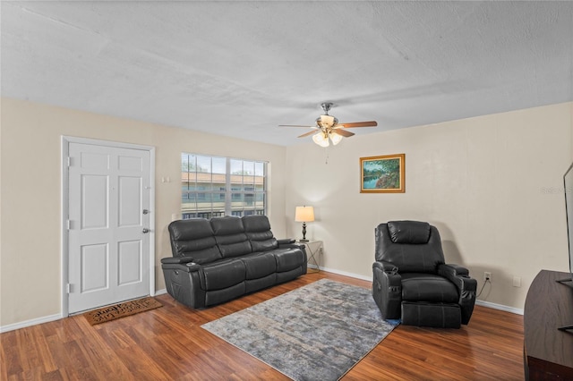 living room featuring hardwood / wood-style flooring, a textured ceiling, and ceiling fan