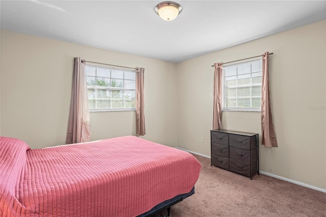 carpeted bedroom featuring multiple windows