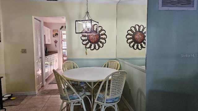 tiled dining area featuring a chandelier and visible vents