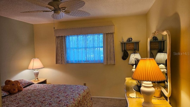 bedroom with a textured ceiling, carpet floors, and a ceiling fan