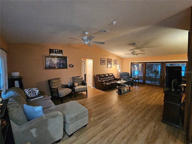 living room featuring hardwood / wood-style flooring, ceiling fan, lofted ceiling, and a textured ceiling