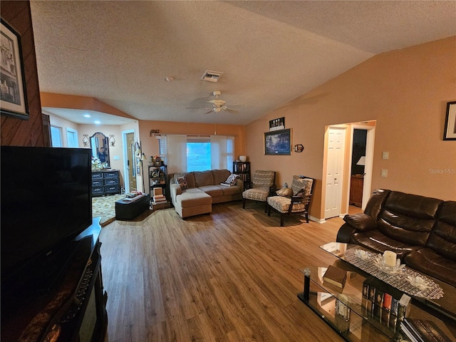 living room featuring lofted ceiling, hardwood / wood-style floors, a textured ceiling, and ceiling fan