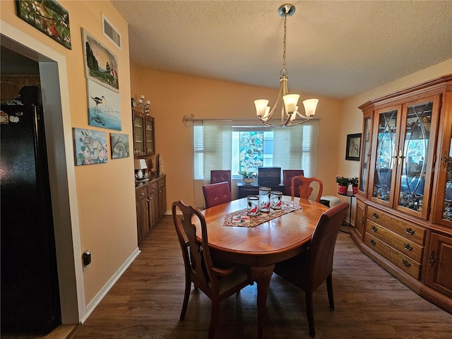 dining area with dark hardwood / wood-style flooring, vaulted ceiling, a textured ceiling, and an inviting chandelier