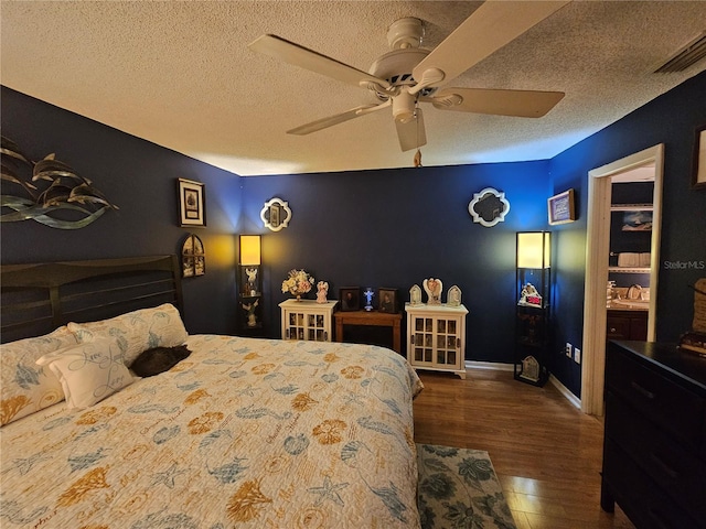 bedroom with ceiling fan, hardwood / wood-style floors, and a textured ceiling