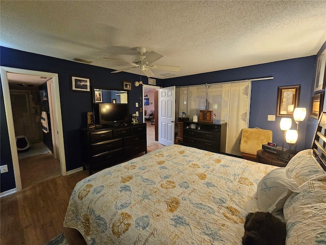 bedroom with wood-type flooring, ceiling fan, and a textured ceiling