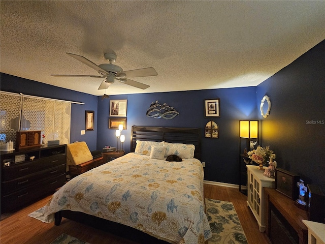 bedroom with hardwood / wood-style floors, a textured ceiling, and ceiling fan