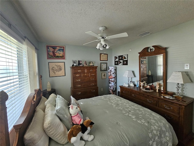 bedroom with ceiling fan and a textured ceiling