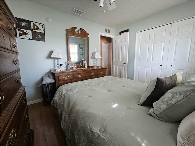 bedroom with ceiling fan, dark wood-type flooring, a textured ceiling, and a closet