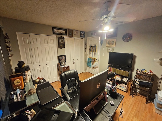 office area featuring ceiling fan, a textured ceiling, and light hardwood / wood-style floors