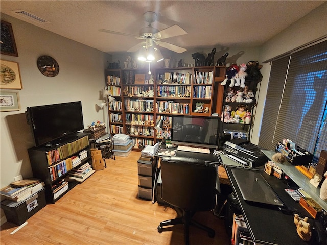 home office featuring ceiling fan, a textured ceiling, and light wood-type flooring