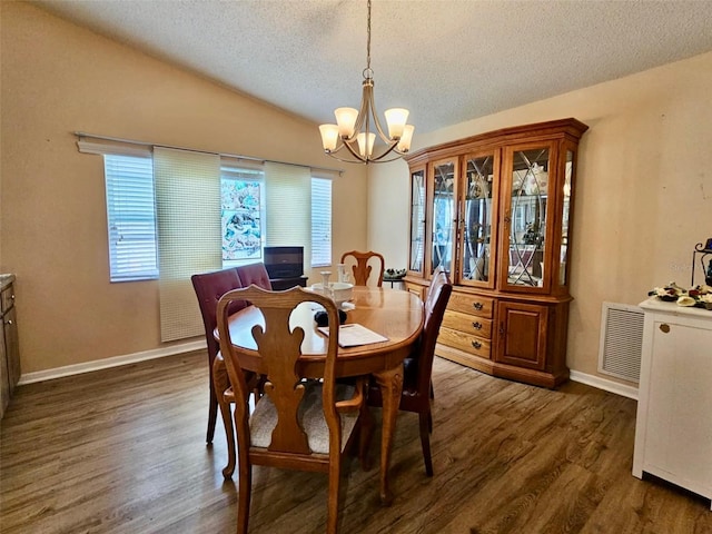 7711 Innis Ct, Saint Petersburg, FL 33709 - dining room featuring a textured ceiling, visible vents, an inviting chandelier, dark wood finished floors, and vaulted ceiling