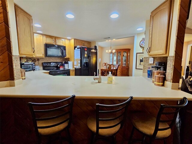 7711 Innis Ct, Saint Petersburg, FL 33709 - kitchen with black appliances, light countertops, decorative backsplash, and a peninsula