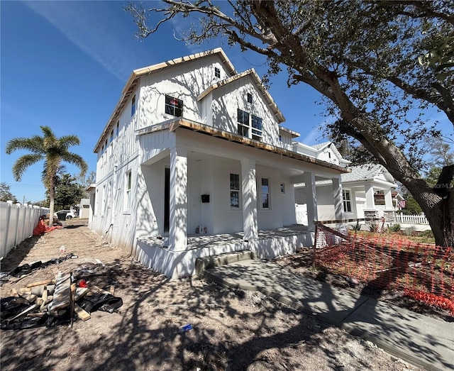 view of front facade featuring covered porch and fence