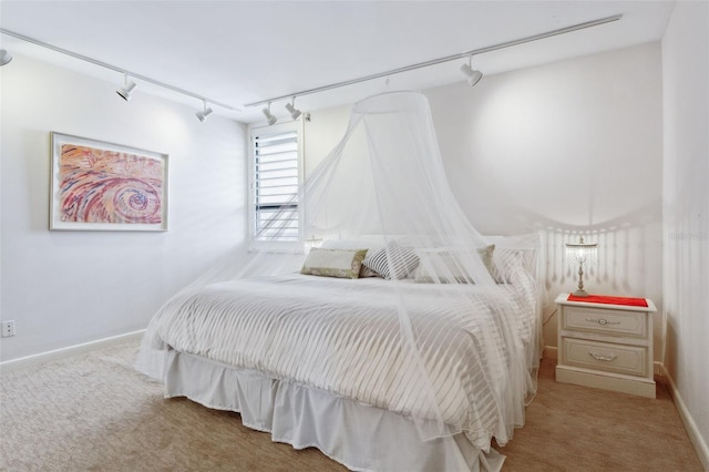 carpeted bedroom featuring rail lighting