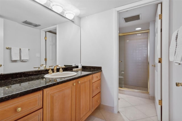 bathroom featuring vanity, a shower with shower door, and tile patterned flooring